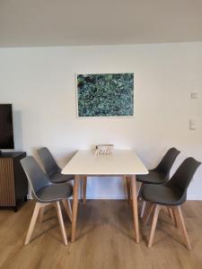 a table and chairs in a room with a painting at ammersee apARTment Dießen in Dießen am Ammersee