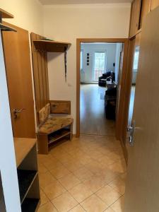 a living room with a hallway with a chair and a door at Apartmán pod Prokopem in Železná Ruda