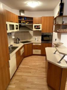 a kitchen with white appliances and wooden cabinets at Apartmán pod Prokopem in Železná Ruda +10 photos