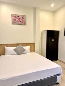 a bedroom with a white bed and a black cabinet at Phúc Đức Hotel in Thanh Hóa