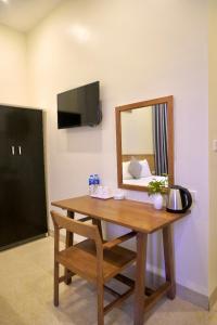 einen Holztisch mit einem Spiegel und einem Stuhl in der Unterkunft Phúc Đức Hotel in Thanh Hóa