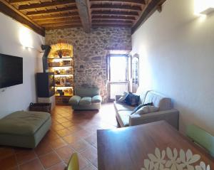 uma sala de estar com uma mesa e cadeiras e uma parede de pedra em Vivi Palagio in Chianti em Aiola