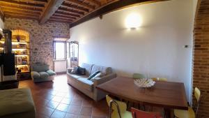 uma sala de estar com uma mesa e um sofá em Vivi Palagio in Chianti em Aiola