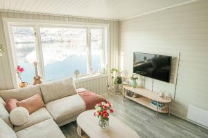 a living room with a couch and a flat screen tv at Koselig toppleilighet med fantastisk utsikt in Svolvær