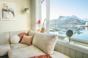uma sala de estar com um sofá e uma grande janela em Koselig toppleilighet med fantastisk utsikt em Svolvær