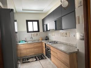 a kitchen with wooden cabinets and a sink and a window at Appartement la gare Rabat ville in Rabat
