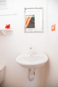 lavabo blanco en el baño con espejo en Las Mariposas, en Las Galeras