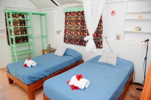 two beds in a room with blue sheets at Las Mariposas in Las Galeras
