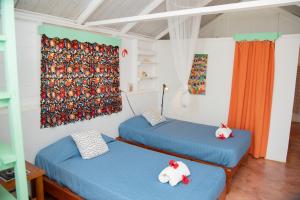 two beds with stuffed animals on them in a room at Las Mariposas in Las Galeras