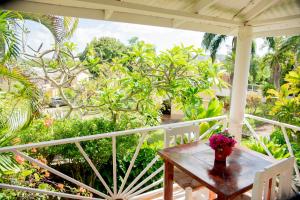 einen Tisch mit einer Blumenvase auf einer Veranda in der Unterkunft Las Mariposas in Las Galeras