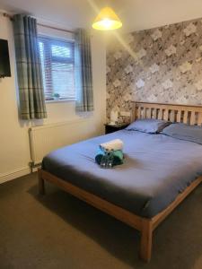 um quarto com uma cama grande e um cobertor azul em The mill wheel em Hartshorne