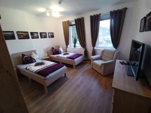 uma sala de estar com duas camas e um sofá em Ferienwohnungen Familie Winter em Dohna