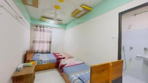 Habitación pequeña con 2 camas y ventana en Hotel Jom Jom International, en Dhaka