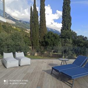 a patio with blue and white furniture and trees at villa Shades of blue in Trapezaki