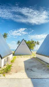 un edificio en forma de pirámide con palmeras en el fondo en Kawaland glamping resort, en Telukbakau