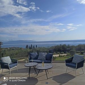 een patio met 2 stoelen en een tafel met uitzicht bij villa Shades of blue in Trapezaki