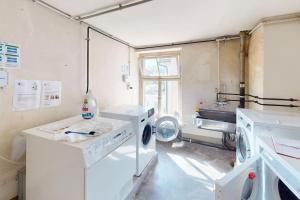 a laundry room with two washing machines and a window at Solution-Grischun - Zentral - Etagenbett - Smart TV - Kaffe&Tee in Chur