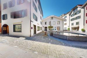 a cobblestone street in a city with white buildings at Solution-Grischun - Zentral - Etagenbett - Smart TV - Kaffe&Tee in Chur