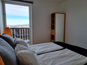 sypialnia z łóżkiem i dużym oknem w obiekcie Lommedalen Panorama 55m2 w mieście Bærums Verk