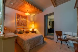 1 dormitorio con cama, mesa y escritorio en le parador suite d'hôtes, en Montfrin
