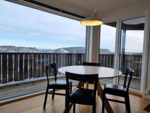 a table and chairs in a room with a large window at Lommedalen Panorama 55m2 in Bærums Verk