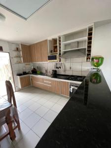 a kitchen with wooden cabinets and a counter top at Kasa Faheina - Praia de Fagundes in Lucena