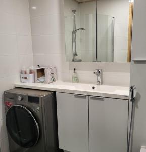 uma casa de banho com um lavatório e uma máquina de lavar roupa em Arctic Apartment with own Sauna em Rovaniemi