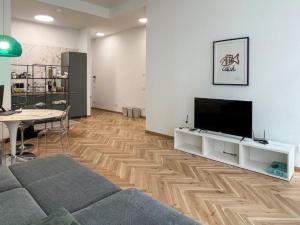 uma sala de estar com uma televisão de ecrã plano e piso em madeira em CasaCri em Turim