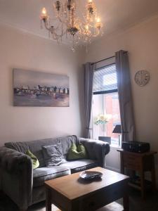 a living room with a couch and a table and a chandelier at Fabulous flat in the fantastic location of Gosforth in Gosforth