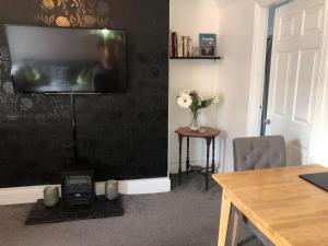 a living room with a television on a wall at Fabulous flat in the fantastic location of Gosforth in Gosforth