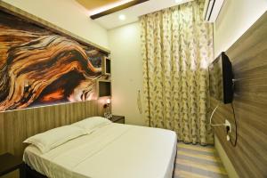 a bedroom with a bed and a painting on the wall at Parkview Homes in Ipoh