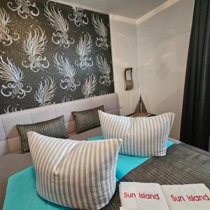 ein Schlafzimmer mit einem Bett und einem Sofa mit Kissen in der Unterkunft Sun Island in Baabe