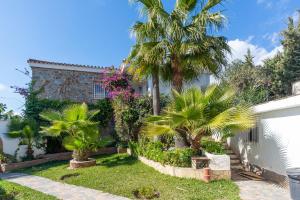 ein Haus mit Palmen im Hof in der Unterkunft Large villa with fantastic views in Benalmádena