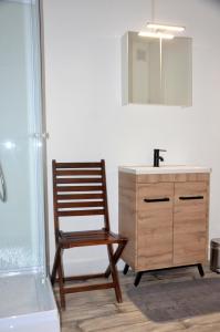 baño con silla de madera junto a un lavabo en studio "Au Bord de l'Eau" 2, en Chambon-sur-Voueize