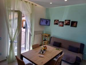 a living room with a table and a couch at Il Talamo di nonna Rosa in Tramonti