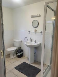 a white bathroom with a toilet and a sink at The mill wheel in Hartshorne +4 photos