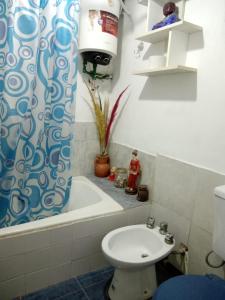 a bathroom with a toilet and a tub and a sink at Cabaña La Solanita in Termas de Río Hondo