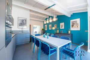 kuchnia z niebieskimi ścianami oraz białym stołem i krzesłami w obiekcie Maison moderne avec piscine et tennis w Saint-Tropez