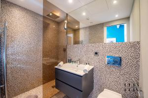 łazienka z umywalką i prysznicem w obiekcie Maison moderne avec piscine et tennis w Saint-Tropez
