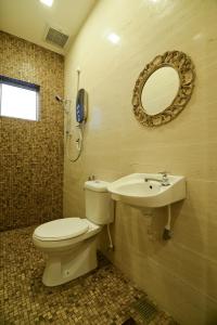 a bathroom with a toilet and a sink and a mirror at Parkview Homes in Ipoh