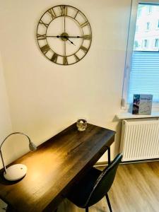 a desk with a large clock on the wall at Ferienwohnung am Fuße Honberg in Tuttlingen