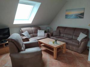 a living room with two couches and a table at Ferienwohnung Lena in Stedesdorf bei Esens an der Nordseeküste in Ostfriesland in Stedesdorf