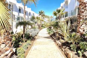 a walkway in front of a building with palm trees at Modern terrassed house close beach in Málaga