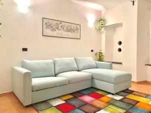 a white couch in a room with a colorful rug at La Marina Vernazza Appartamento Piazza Marconi in Vernazza