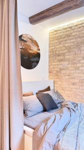 a bedroom with a bed and a brick wall at Angel House Vilnius, 17 in Vilnius