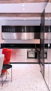 a kitchen with stainless steel appliances and a red chair at Angel House Vilnius, 17 in Vilnius