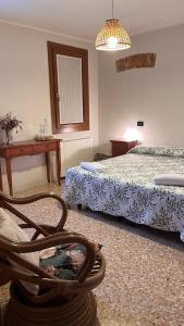 a bedroom with two beds and a chair with a basket at Colombara Farmhouse in Mestrino