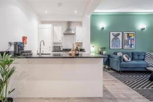 a kitchen and a living room with a blue couch at Stay Kula London - Tower Bridge in London