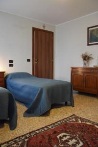um quarto com uma cama azul e um armário de madeira em Colombara Farmhouse em Mestrino