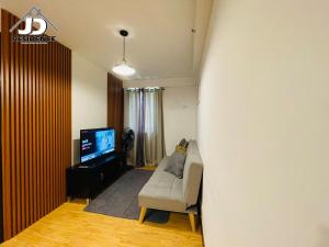 sala de estar con sofá y TV en JD Residence - 1 Bedroom Unit, en Davao City